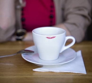 White coffee cup and saucer with trace of red lipstick