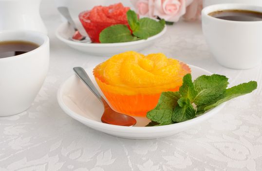 Dessert of orange jelly with fresh orange slices with a cup of coffee