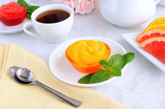 Dessert of orange jelly with fresh orange slices with a cup of coffee

