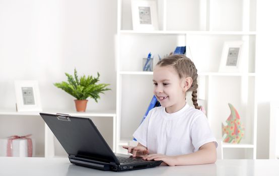 girl working on laptop at home, sitting at the table