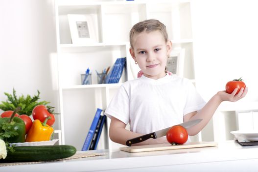 beautiful girl in the kitchen cooking vegetables