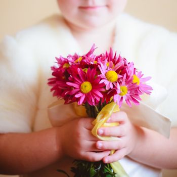 little girl with pink flowers asters in their hands