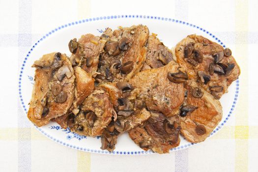 Meat with mushrooms on the plate
