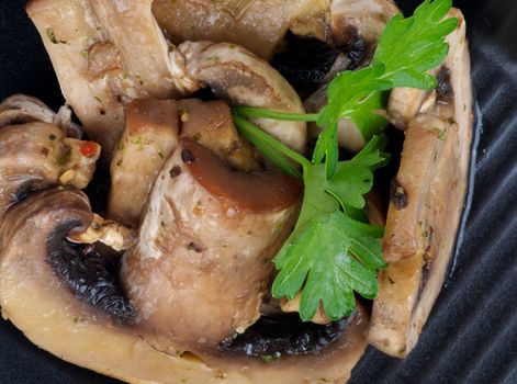 Stack of Cooked Mushrooms with Parsley on black plate