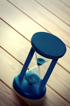 Hourglass on wooden boards.