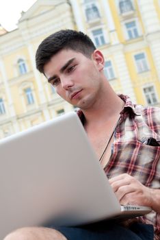 Young man with laptop on lap.