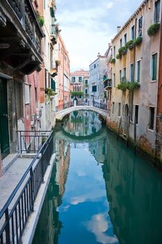 green and blue water of a typical venetian canal, Italy