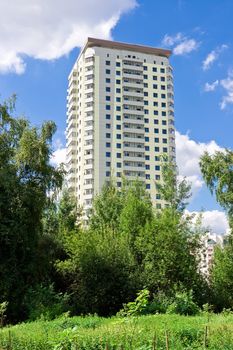 Modern apartment building under blue sky in a green district