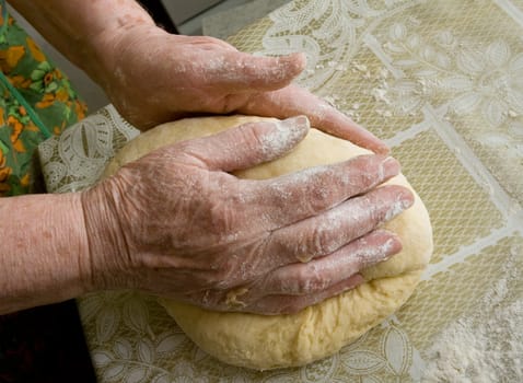 Hands of old woman making dough