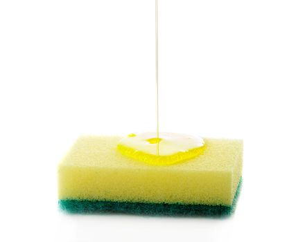 Liquid soap being poured on a dish sponge.