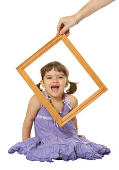 Happy little girl looking through the frame isolated on white background