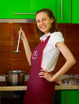 Cheerful young woman preparing food in the kitchen