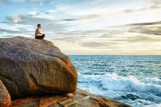 A man practices yoga on the coast - Meditation