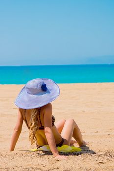 Photo of a young and beautiful woman resting on the sea coast