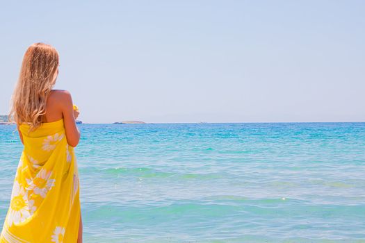 Photo of a young and beautiful woman resting on the sea coast