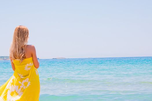 Photo of a young and beautiful woman resting on the sea coast