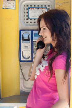 Photo of a young and beautiful woman in a phone booth