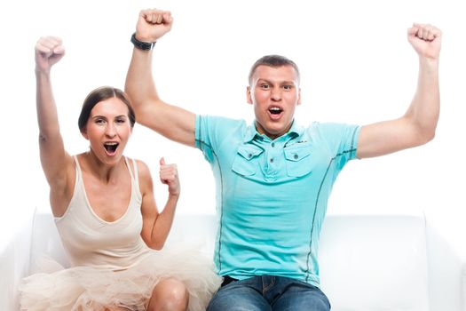Group of sports fans watching the competition sitting on a white sofa