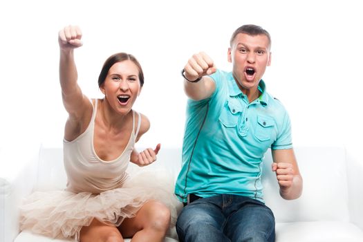 Group of sports fans watching the competition sitting on a white sofa