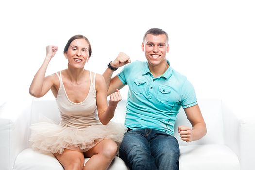 Group of sports fans watching the competition sitting on a white sofa