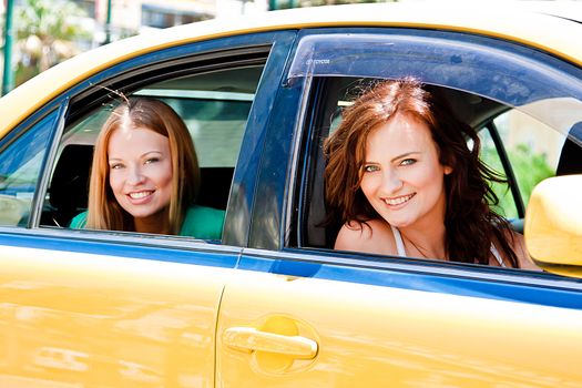 Photo of two young and beautiful women in the taxi