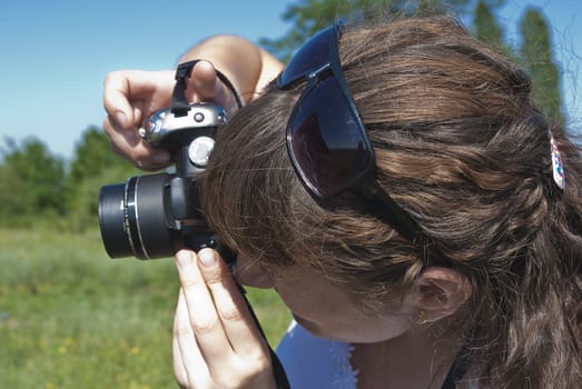 Young women is shoot landscape against a meadow and sky