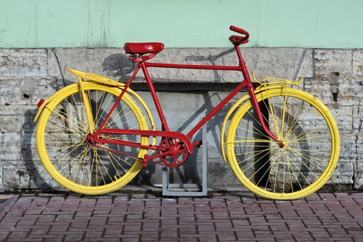 old yellow bicycle stands at the walls the city houses