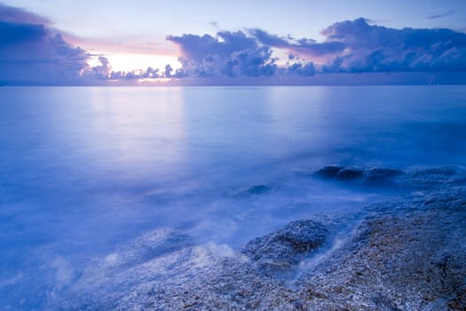 Landscape of sea with rock in sunset.