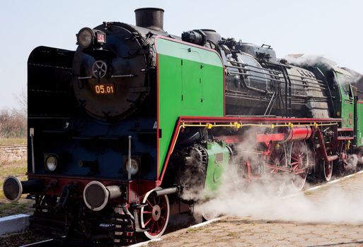 View of steam train leaving from a station platform