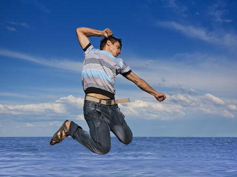 Boy jumping against a background of beautiful sky