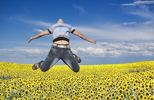 Boy jumping against a background of field and sky