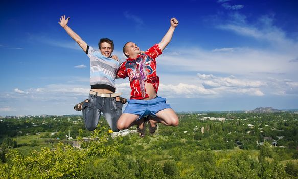 Boys jumping against a background of beautiful sky