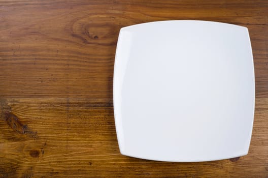 Empty white plate on wooden table