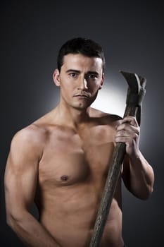 Young worker with pickaxe over black background