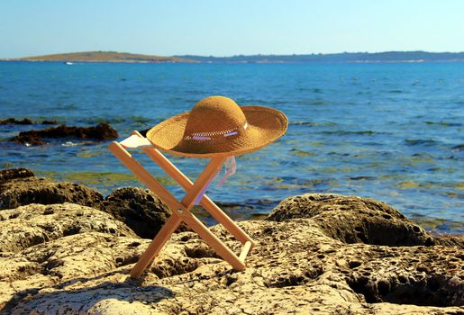 Hat on the chair near the sea. A concept of summer, vacation, relaxing, joy.