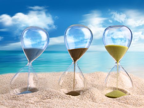 Three hourglass in the sand with blue sky