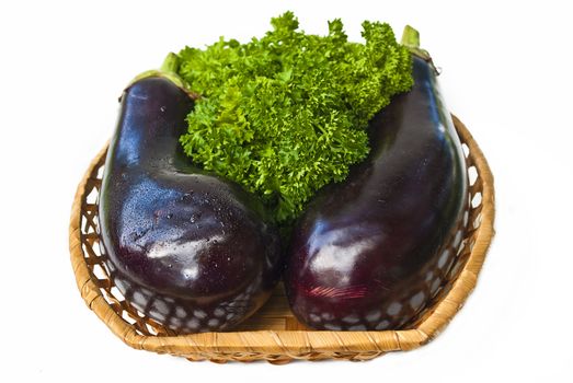 Two aubergine in wood bowl isolated over white