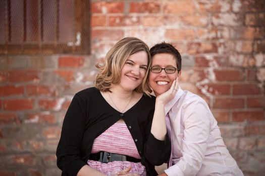 Lesbian couple sitting next to each other outdoors