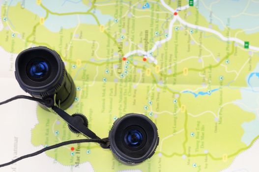 Concept of trip to Thailand with binocular on Thai map, focus on binocular