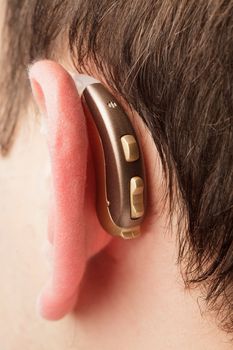 Hearing aid on the man's ear closeup