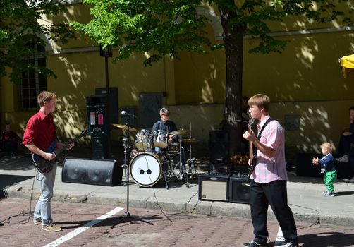 VILNIUS, LITHUANIA MAY 2012. Young students playing guitar and drums in city center. Hard rock. Street music day.