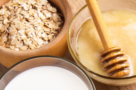 Milk and honey on the wooden table closeup