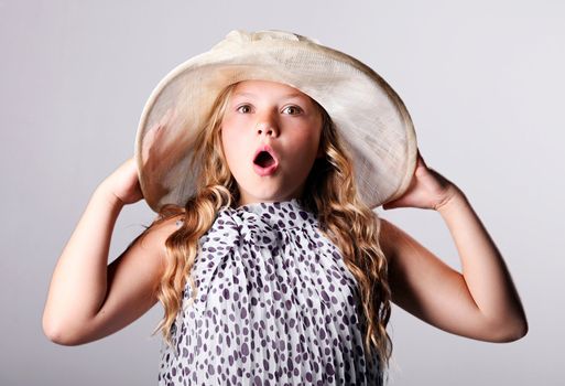 Surprised girl in summer hat over white background