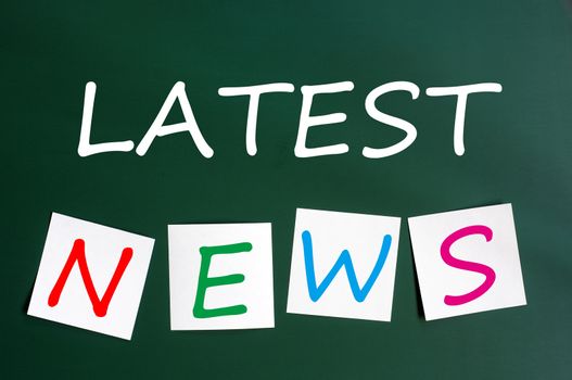 Chalk drawing of Latest news with sticky notes on a green chalkboard