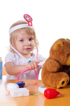 Little girl playing as doctor with stethoscope on white