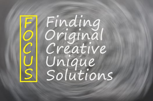 Focus acronym for Finding,Original,Creative,Unique,Solutions written on a blackboard