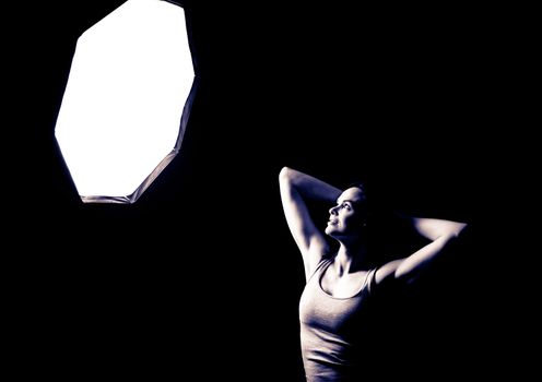 A beautiful woman posing and looking into a studio light