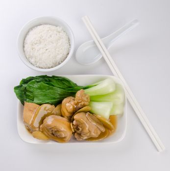 Chicken with rice and vegetables in background