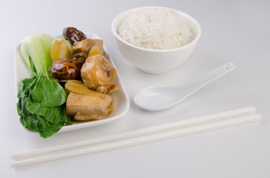 Chicken with rice and vegetables in background