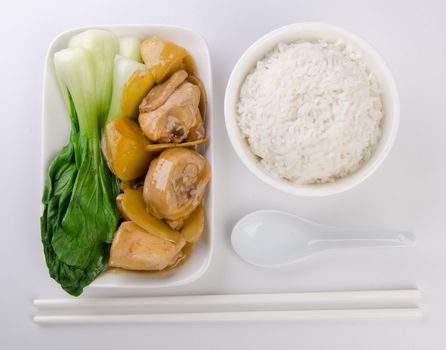 Chicken with rice and vegetables in background